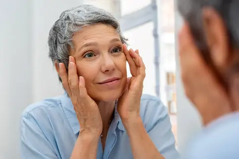photo of mature woman looking in mirror